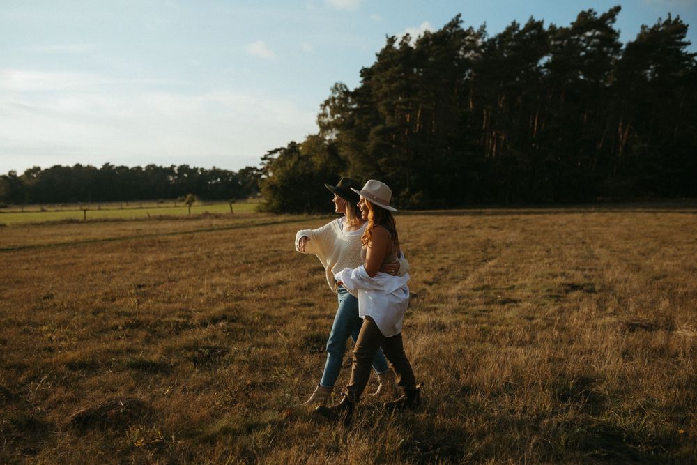 People enjoying themselves in an open field with pine trees in the background.