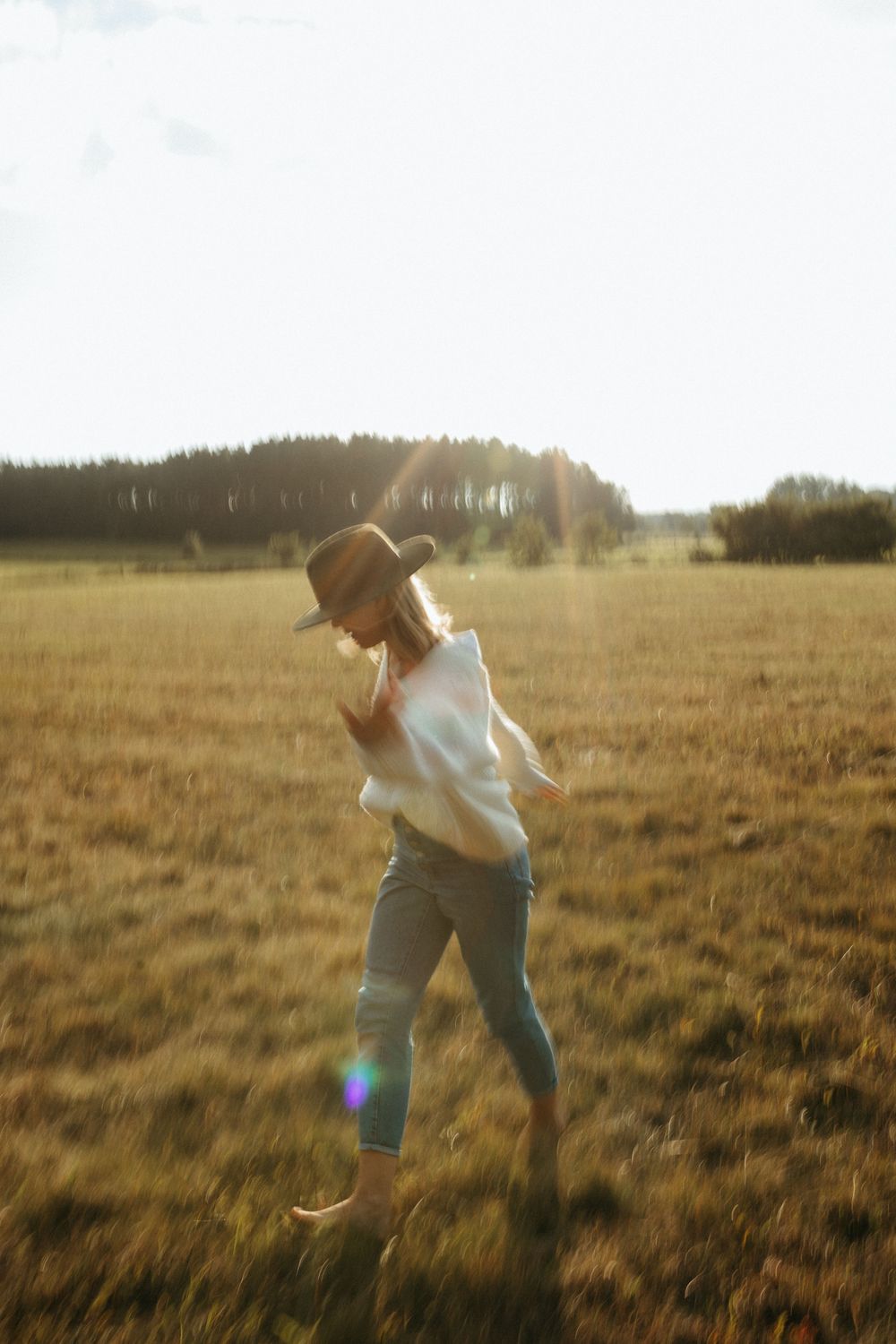 Friends leaping through a golden meadow during magic hour.