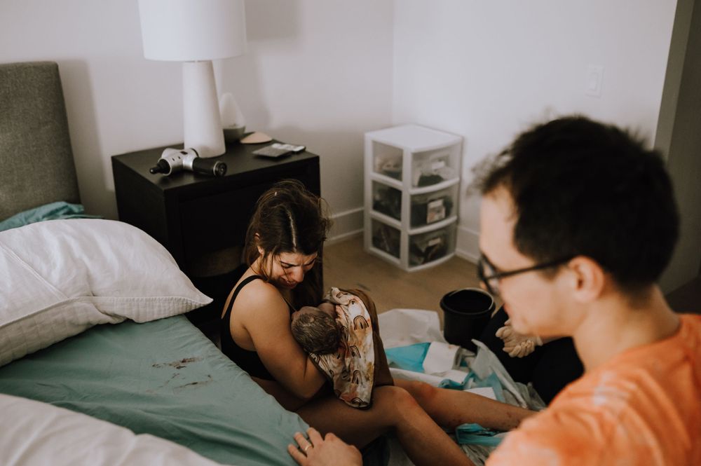 Two people sharing a relaxed moment together while lounging in a bedroom with white and green bedding.
