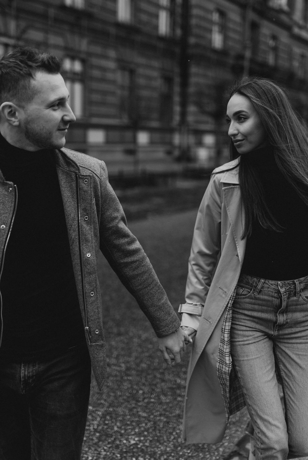 Black and white portrait of couple in winter attire sharing loving glances.