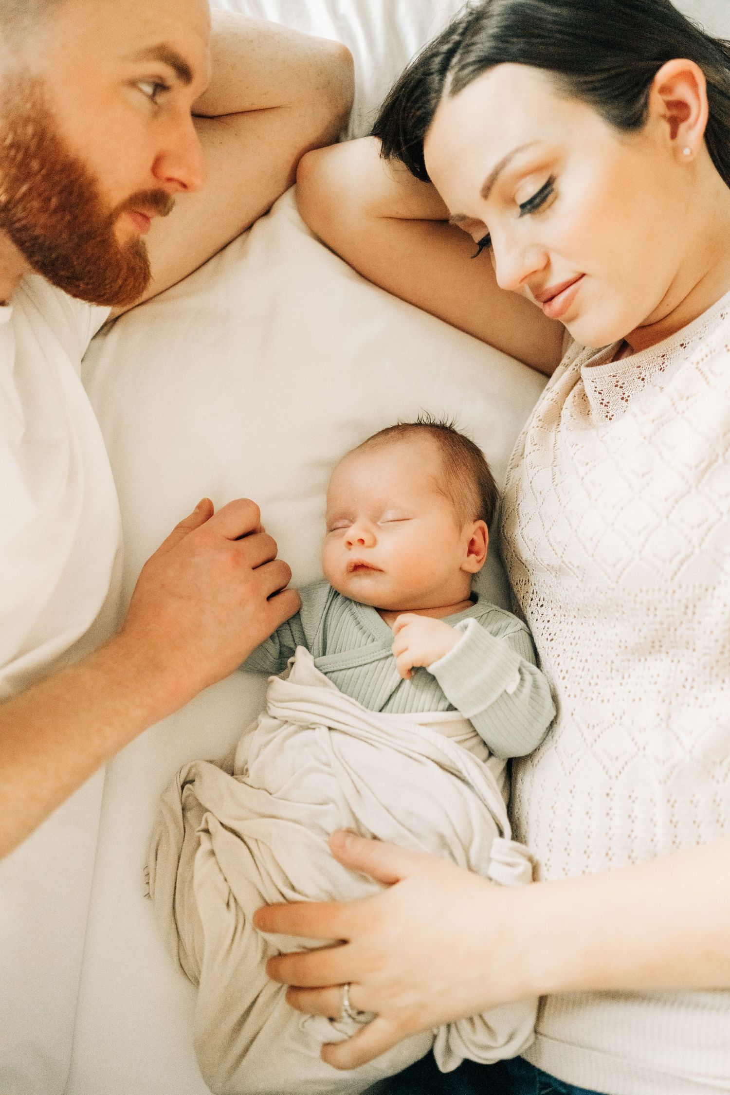 laying on a bed during an in home newborn session in Frisco, TX