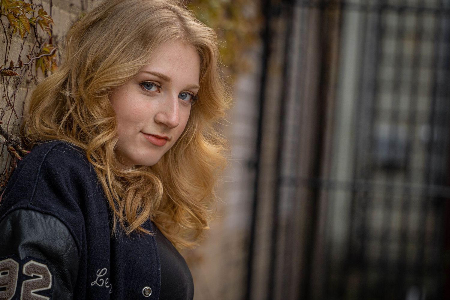 Young woman wearing letter jacket for senior portrait