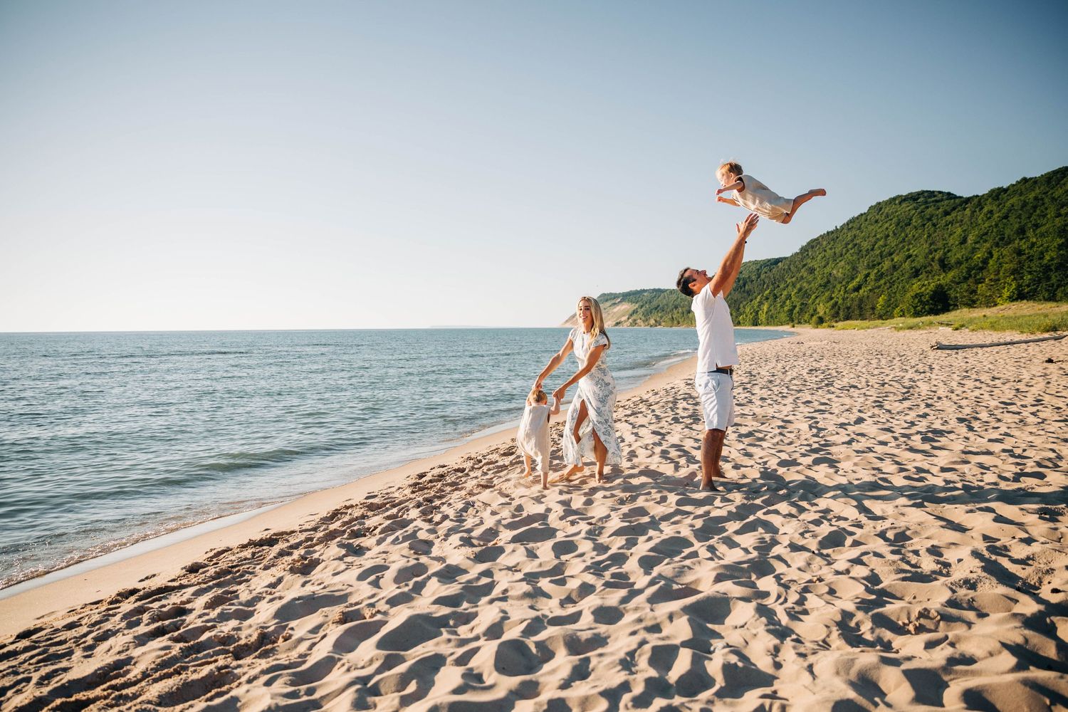 A family with mom, dad, and two small boys playing on the beach in Sleeping Bear Dunes Leelanau Traverse City Photograph