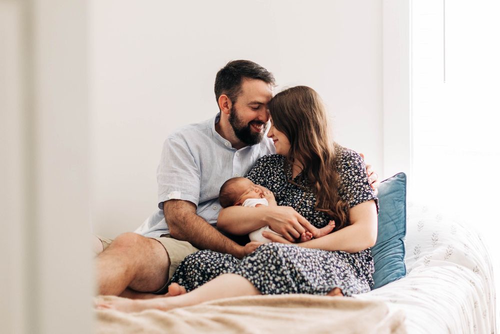 An intimate indoor scene showing a tender moment with a newborn baby.