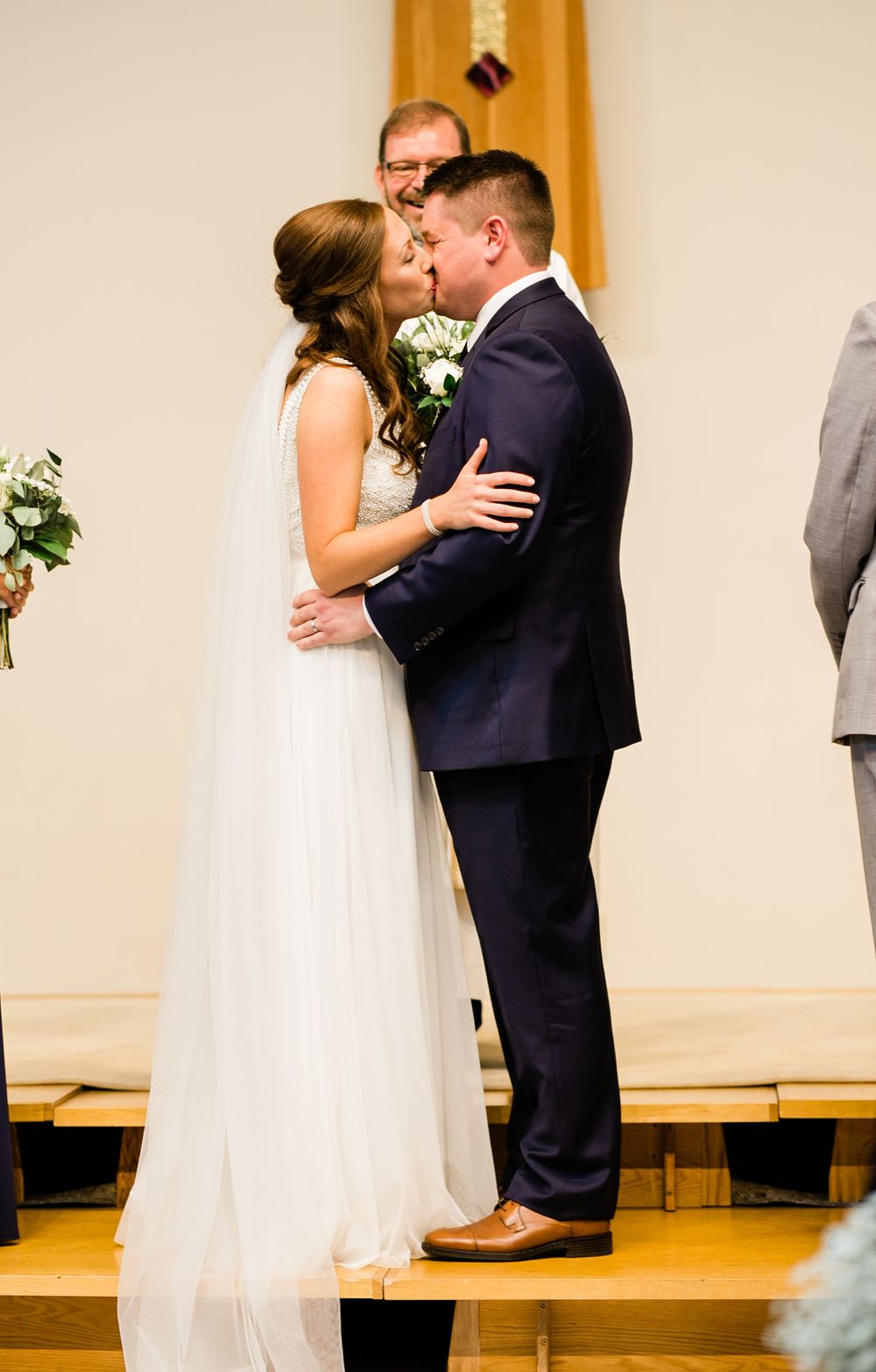 Bride and groom share their first kiss at the altar during a church wedding ceremony.