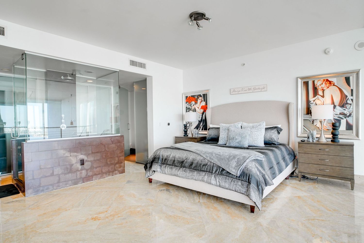 a professional real estate photo of a modern, well-decorated bedroom in a miami condo apartment