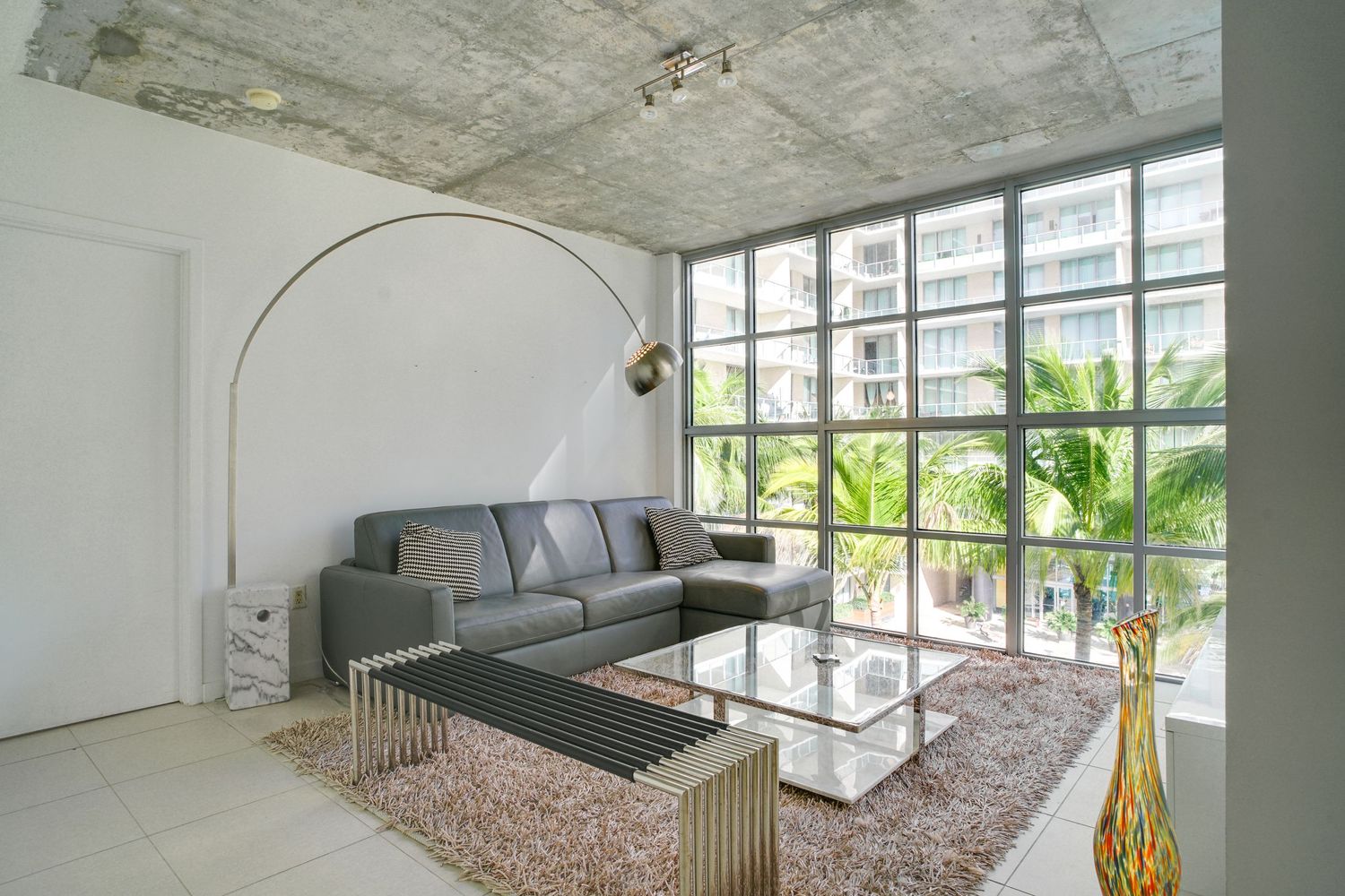 a professional real estate photo of a modern, well-decorated living room in a miami condo apartment