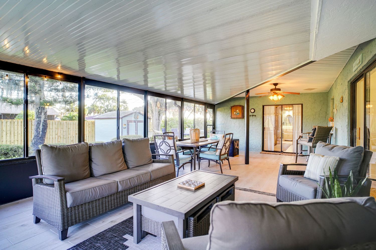 a professional real estate photo of a modern, well-decorated back porch living space in a home in florida