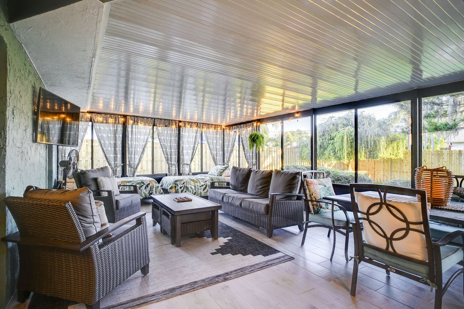 a professional real estate photo of a modern, well-decorated back porch living space in a home in florida
