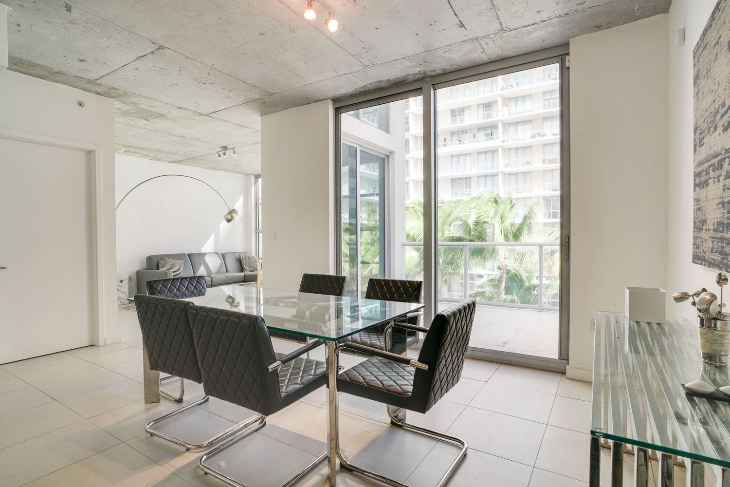 a professional real estate photo of a modern, well-decorated living room in a miami condo apartment