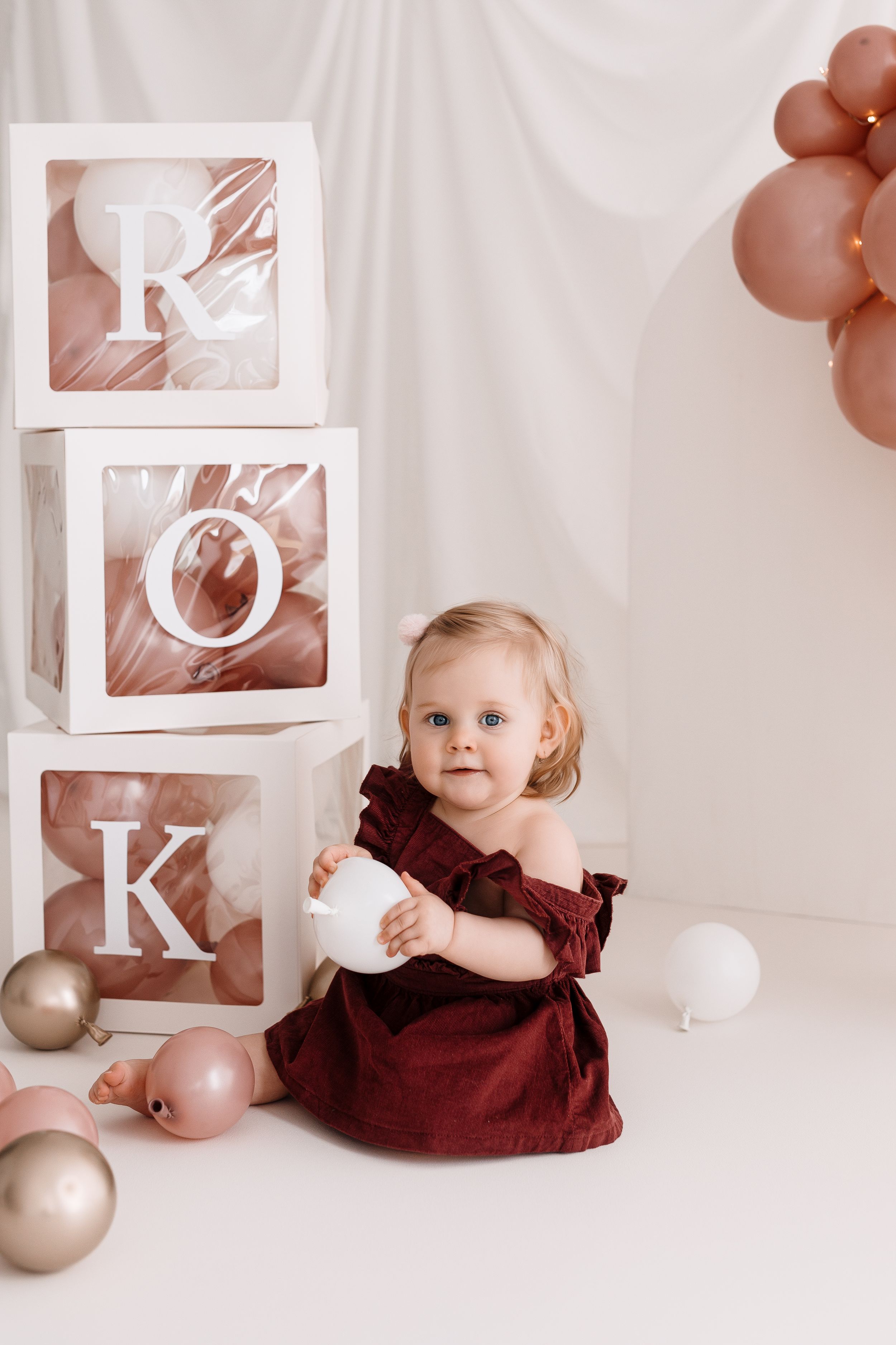 Professional studio setup with letter blocks and pink balloon decorations.