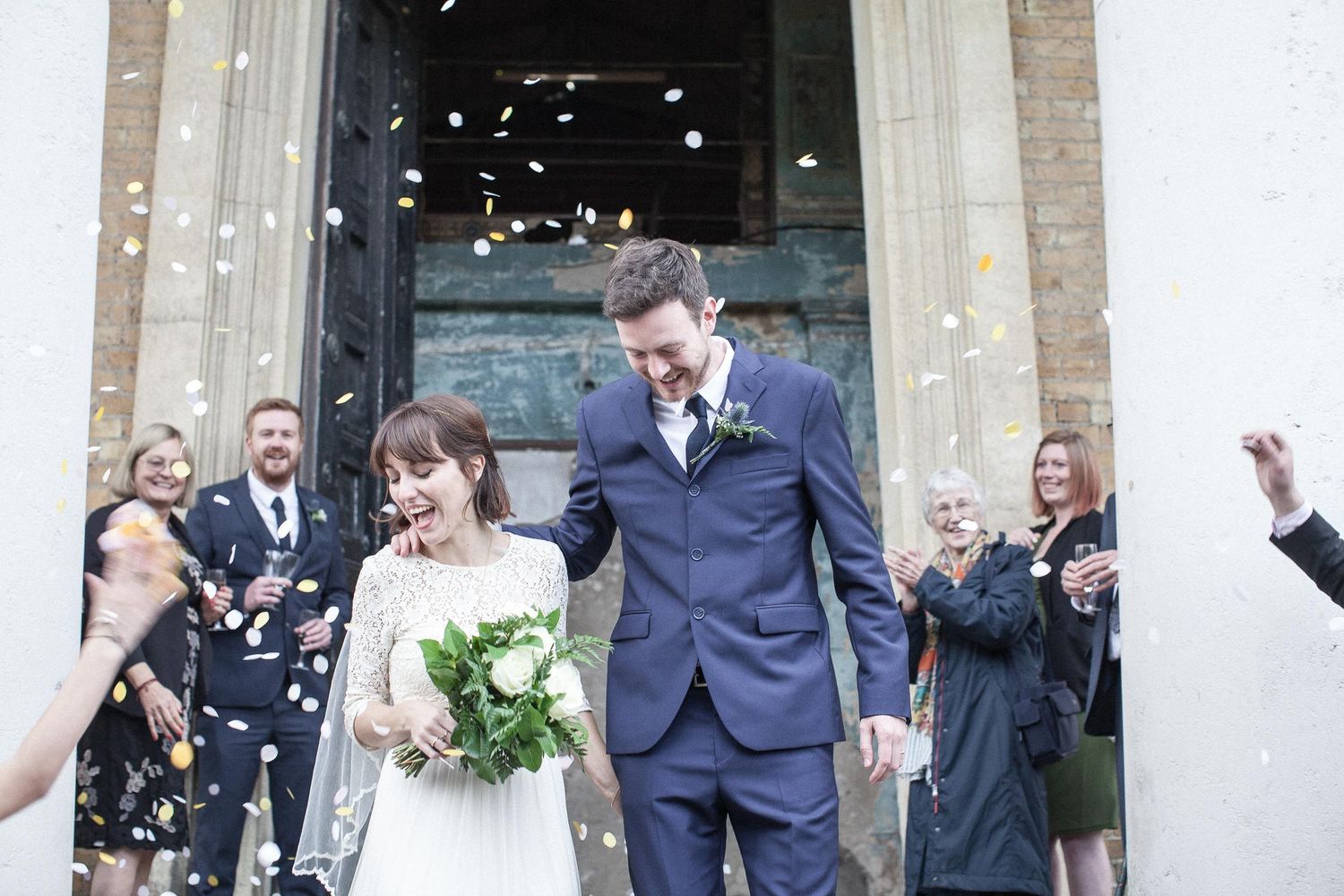 Bride and Groom leaving church. Guests either side throwing confetti
