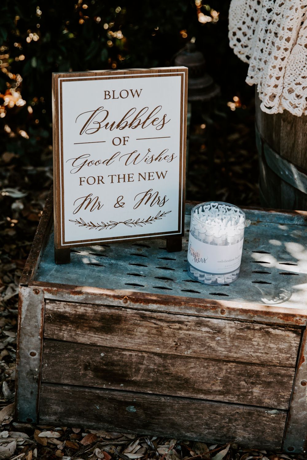Wedding sign for bubble blowing with 'Mr & Mrs' text displayed on weathered wooden surface.