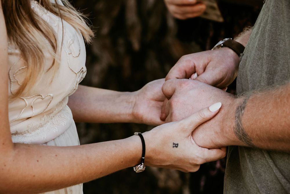Close-up of hands tenderly touching during intimate moment.