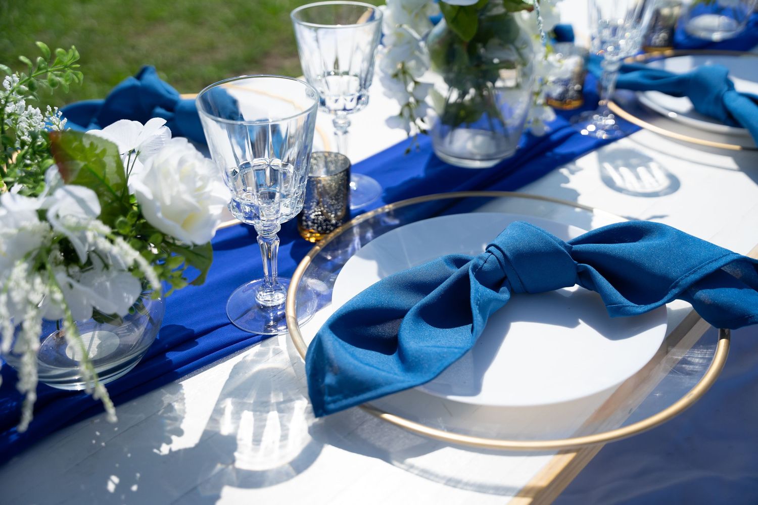 Elegant table setting with blue napkins and crystal glassware for formal dining.