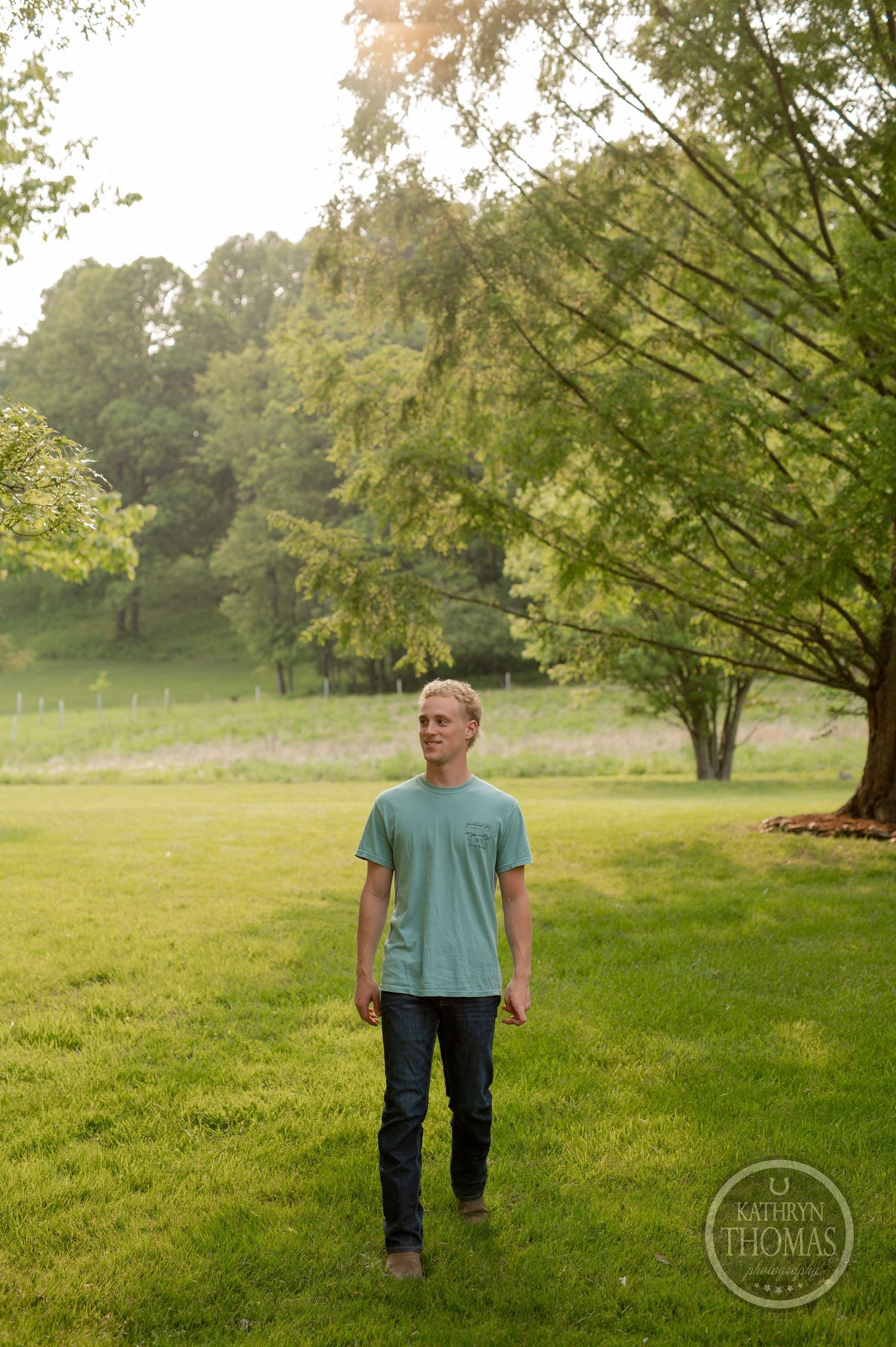 A figure stands in a serene garden setting with green grass and trees in the background.