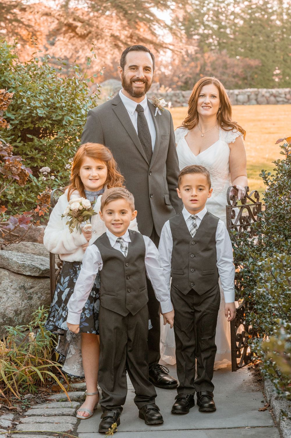 Family portrait on garden path with fall colors in background.