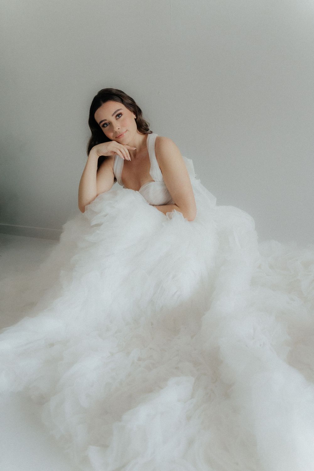 Girl posing elegantly at a bridal show, showcasing a stunning wedding dress with a smile