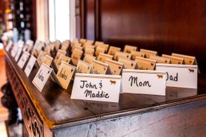Wedding reception name cards arranged in a vintage wooden box with labels for family members.
