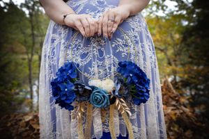 Close up of blue and white floral wedding bouquet with lace details.