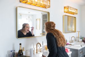 Getting ready scene with elegant lighting and gold-framed mirrors in a bridal preparation room.