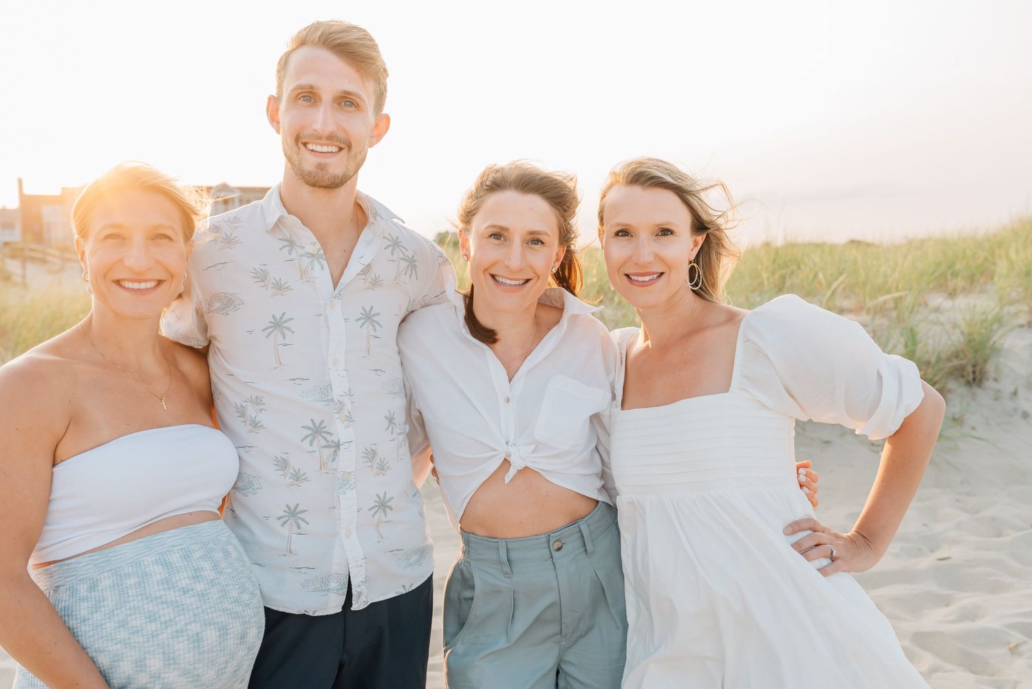 Siblings hug arms on the spring lake beach for their family photo session.