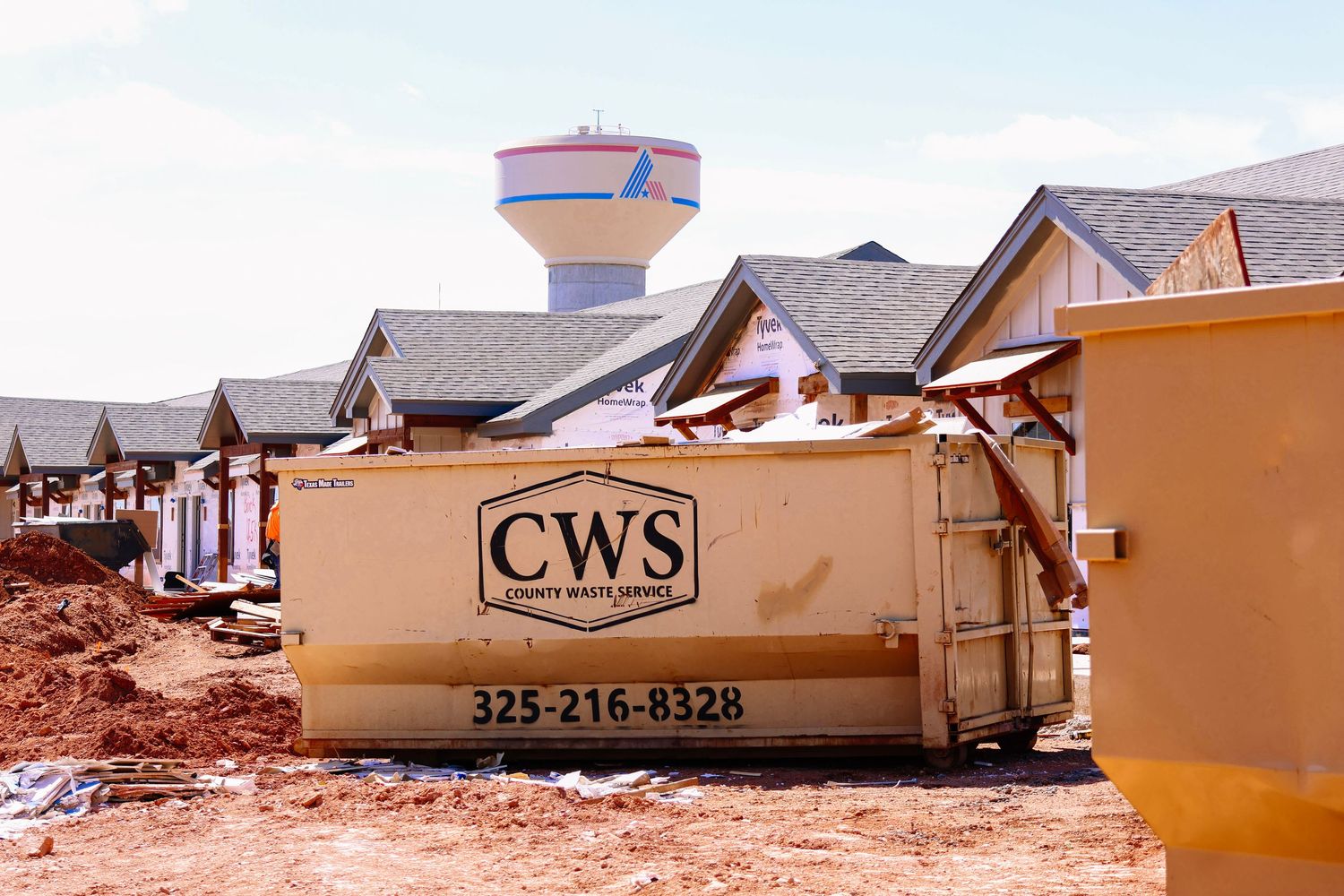 Row of residential houses under construction in desert landscape.