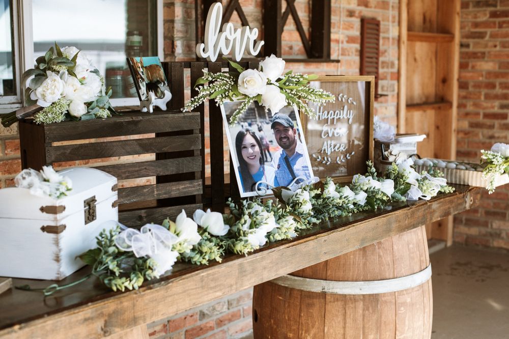 Rustic wedding decor display with wooden crates, white floral arrangements and signage.