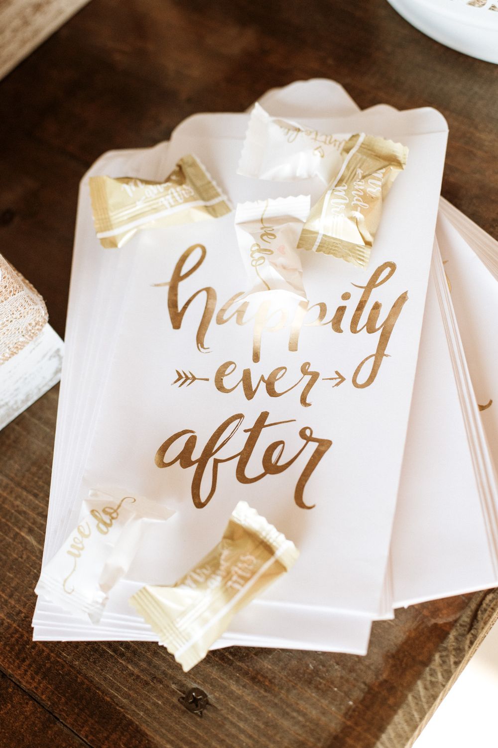 Elegant white and gold 'Happily Ever After' wedding sign with decorative bows.