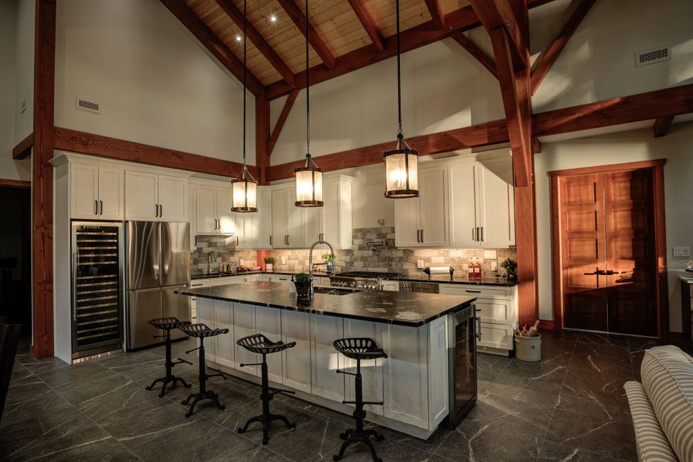 Modern kitchen and bar area featuring timber frame construction and pendant lighting.