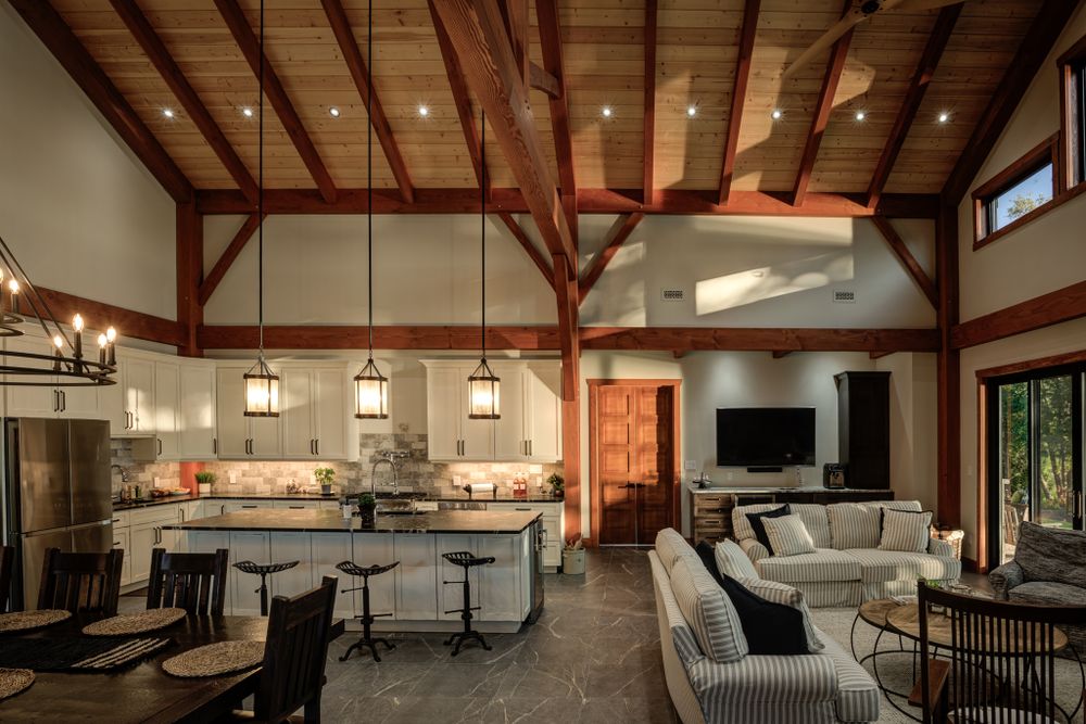 Open concept living space with exposed timber beams, modern furnishings and high ceilings.