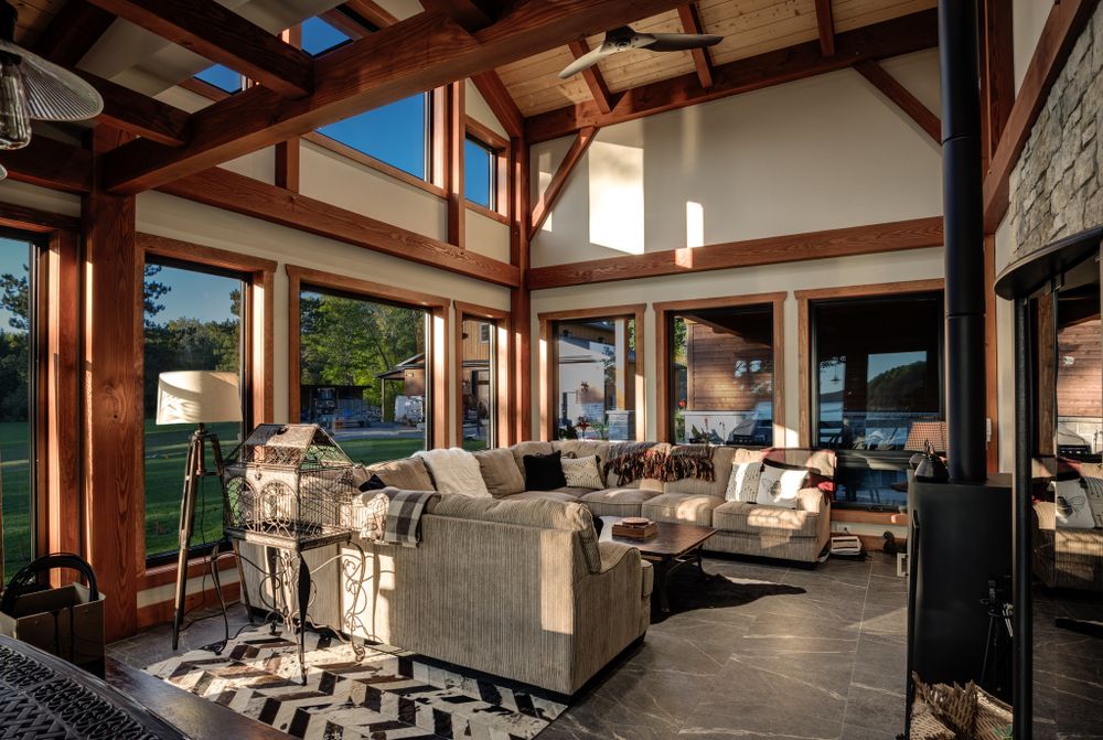Modern outdoor living space with exposed wood beams and stone columns overlooking scenic mountain views.
