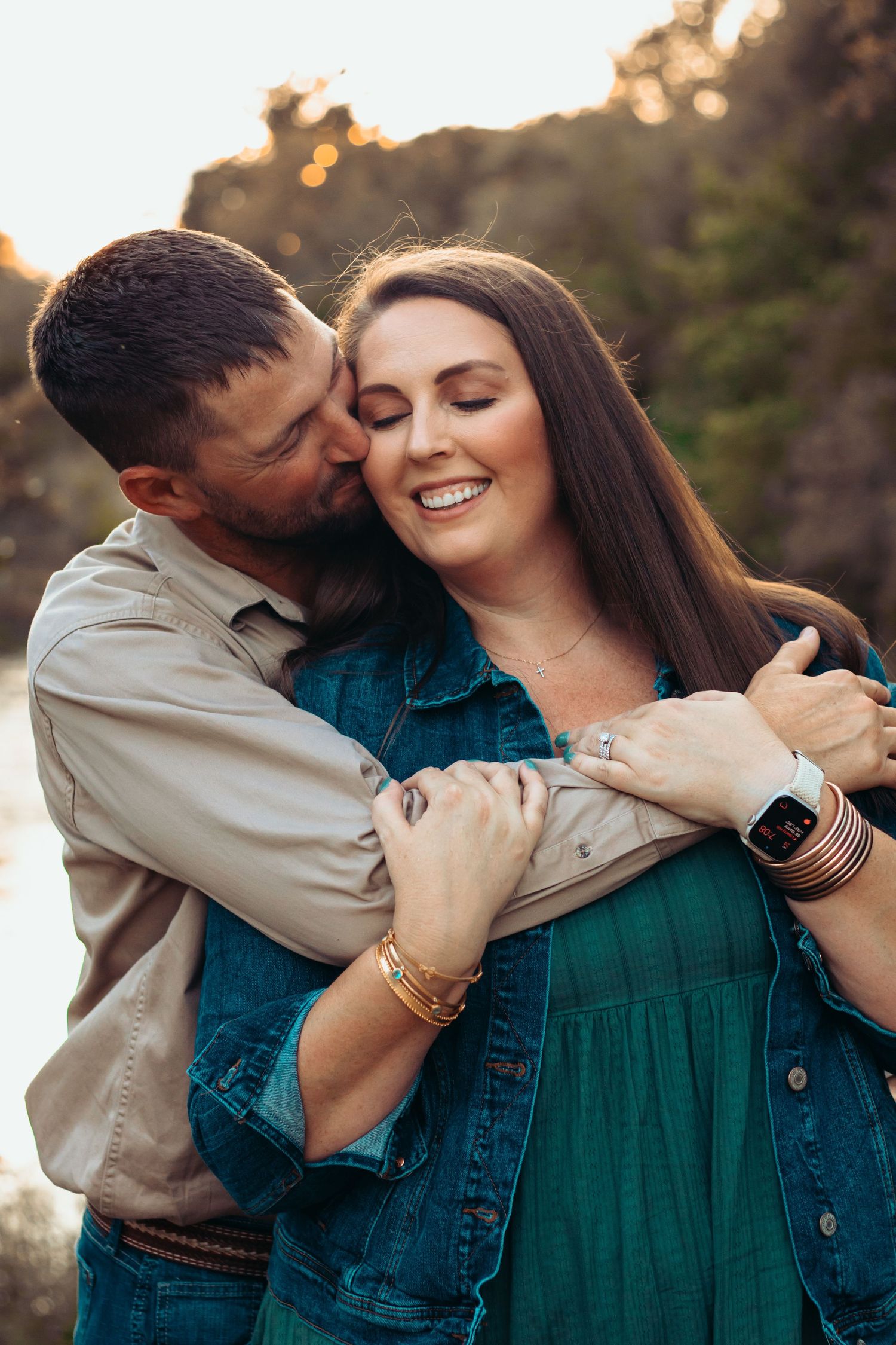 A romantic couple shares tender moments during an outdoor sunset photoshoot.