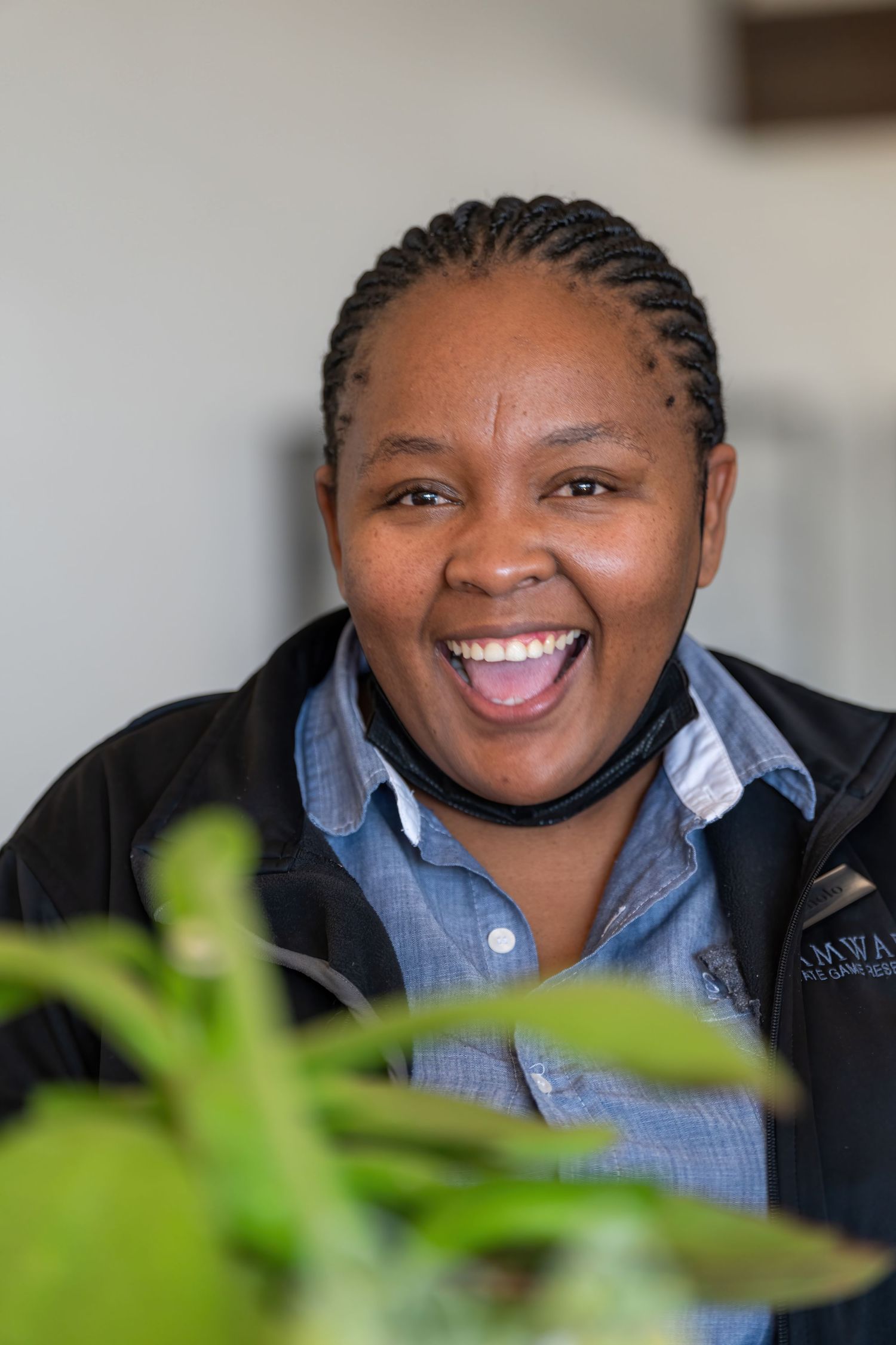Hospitality professional in blue shirt and black jacket smiling warmly.