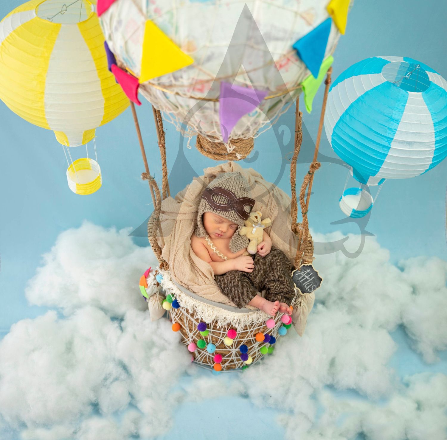 Whimsical hot air balloon themed setup with colorful paper lanterns floating among fluffy clouds.