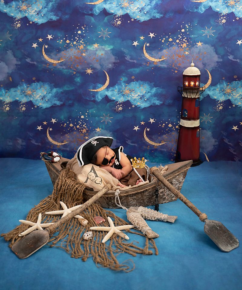 Sleeping baby in nautical themed set with lighthouse, fishing nets, and starfish decorations.