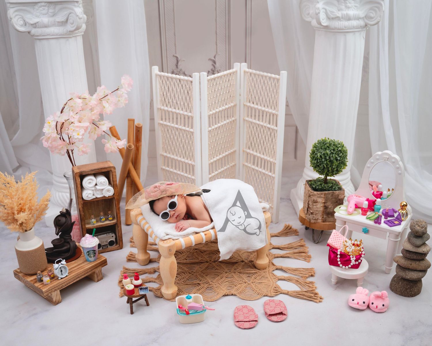 Dreamy nursery photo setup with white dividers, wooden props, and soft pink accessories.