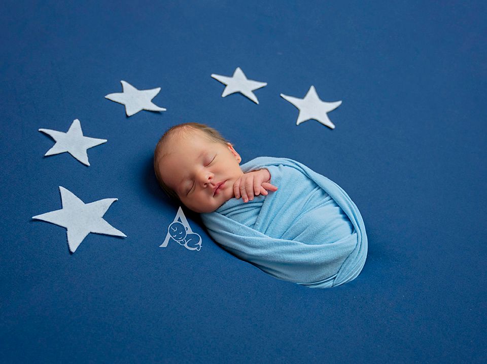 Newborn Baby swaddled with fabric stars