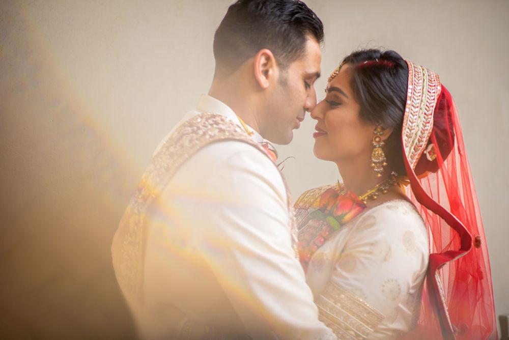 Romantic close-up of a couple in traditional South Asian wedding attire.