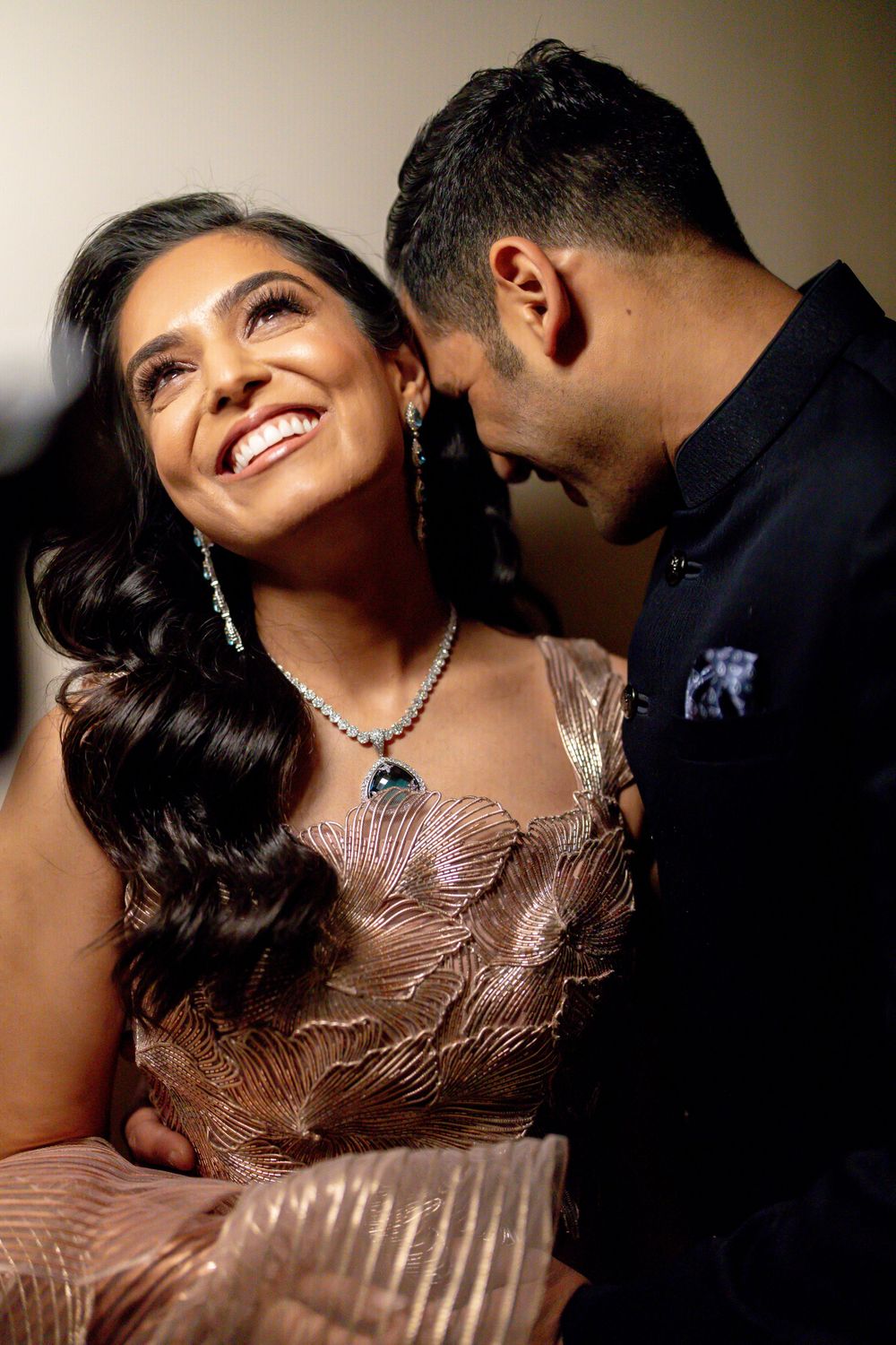 Elegant couple sharing an intimate moment in formal attire with sparkly dress details.