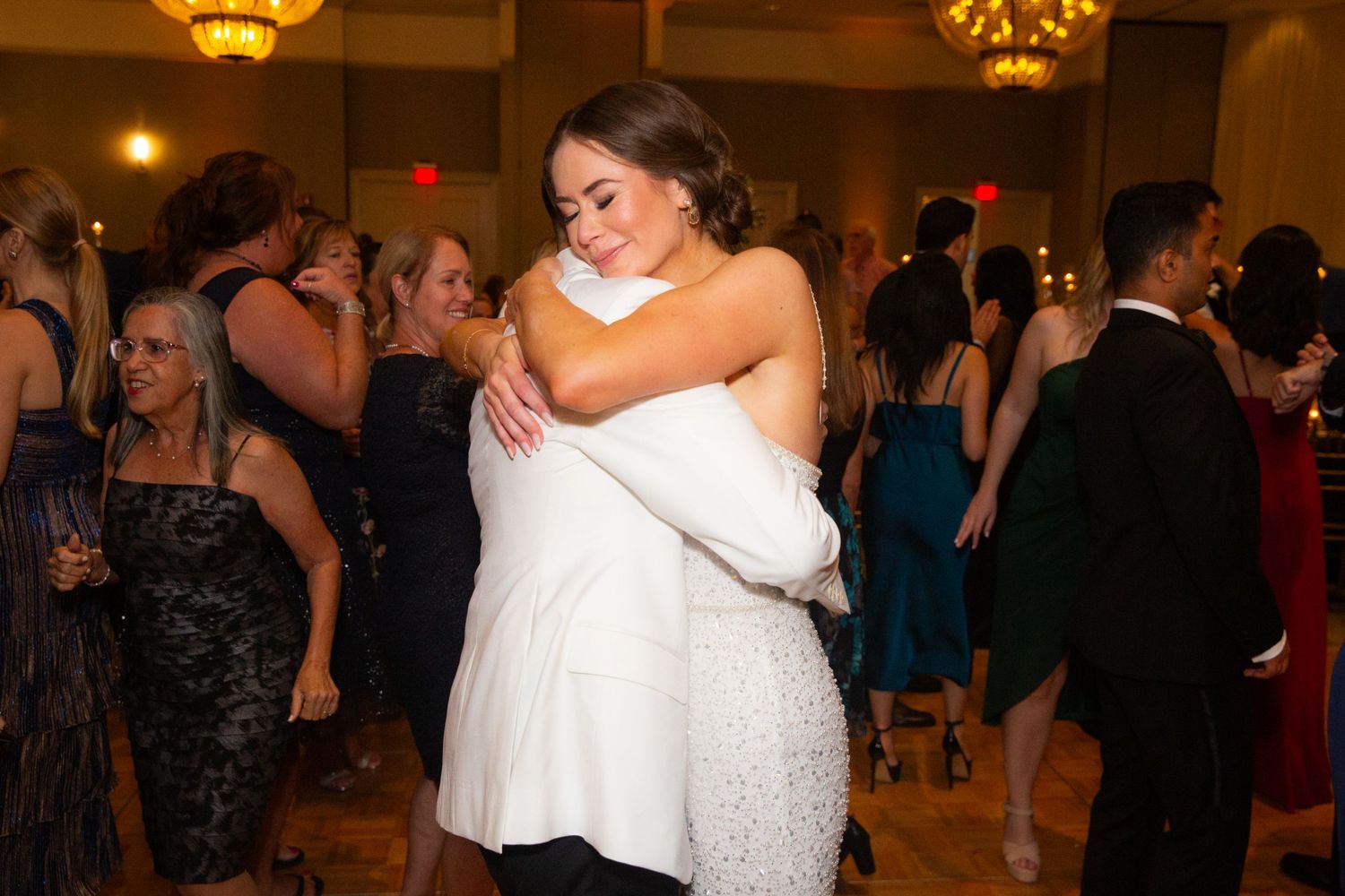 Elegant ballroom filled with celebration as guests dance at a formal event.