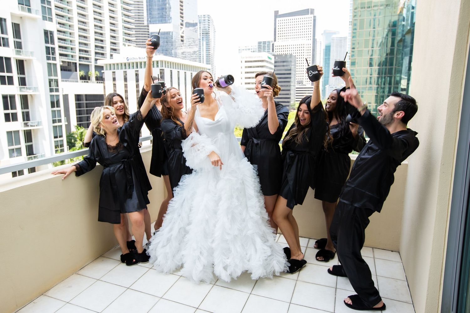 Wedding celebration on a modern urban rooftop with guests cheering.