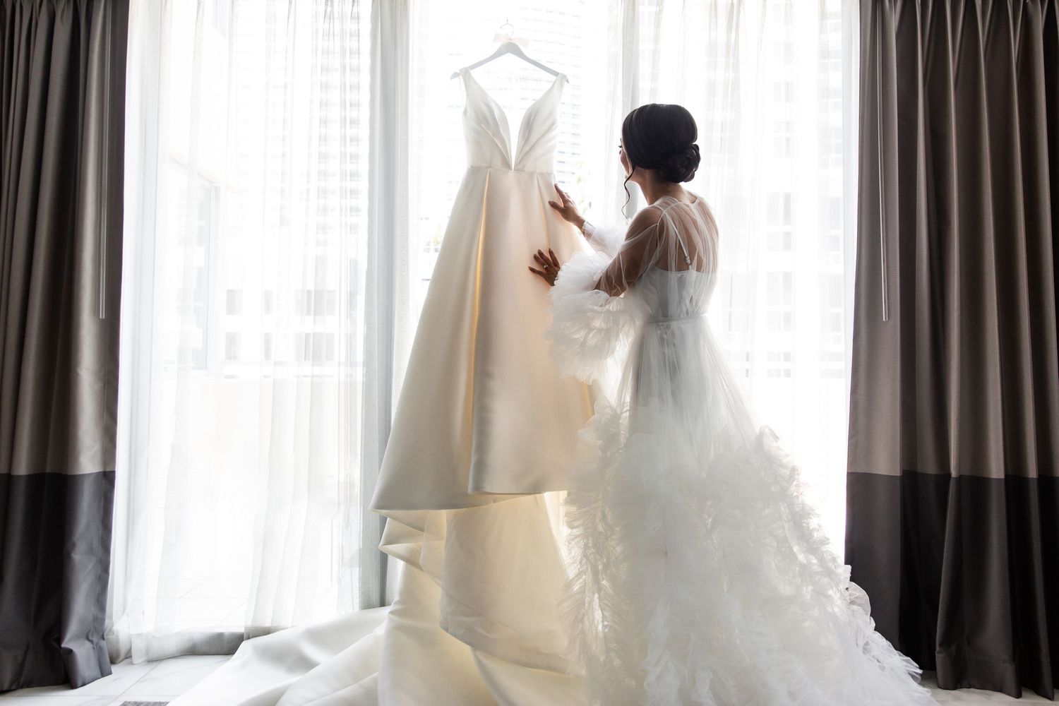 Ethereal bridal portraits with white wedding gown against window light.