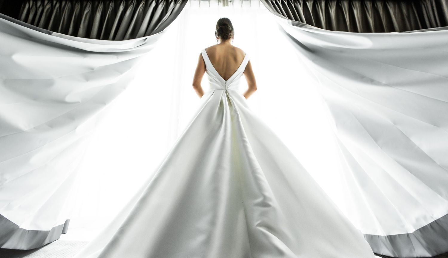 Details of elegant white wedding dress with dramatic pleating and architectural design.