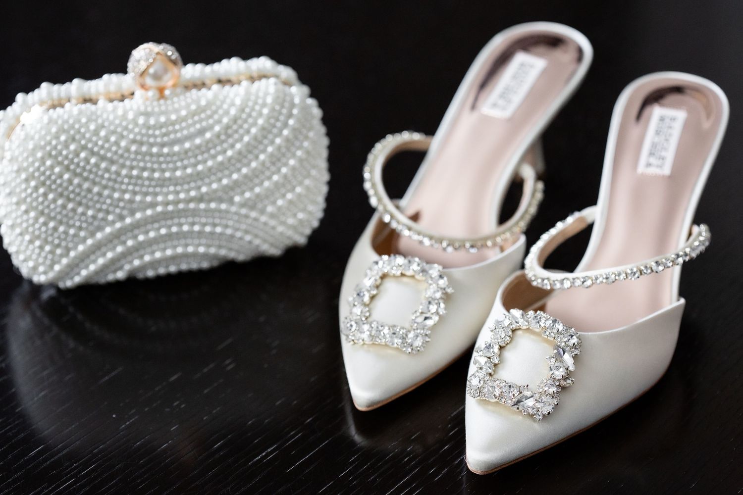 Collection of elegant white bridal shoes with pearl and crystal embellishments.