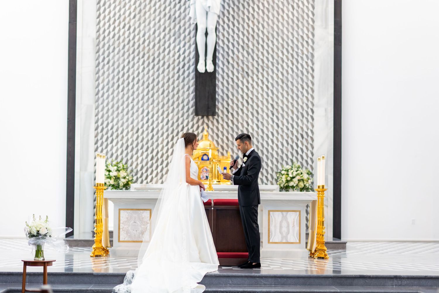 Modern church sanctuary with white geometric walls and prominent crucifix display.