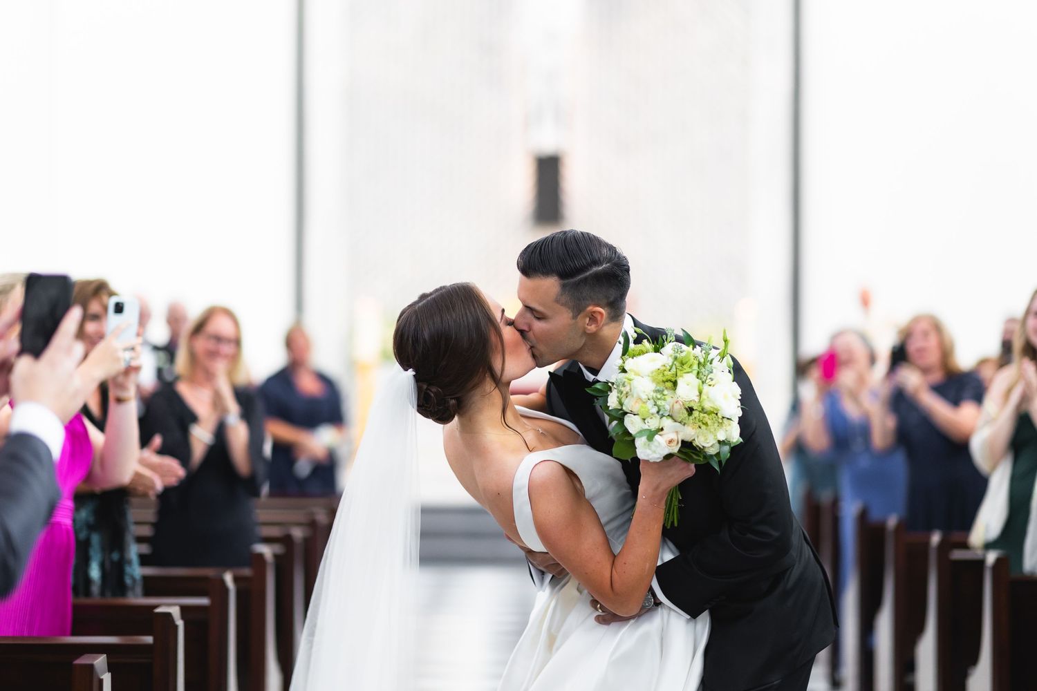 Wedding party in black and white attire standing in an elegant venue.
