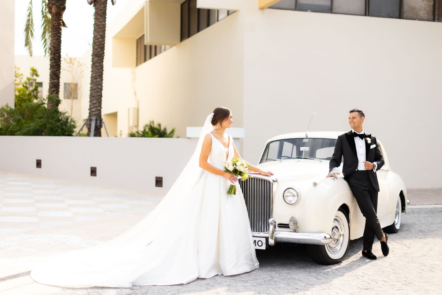 Elegant wedding photos with vintage white Rolls Royce car.