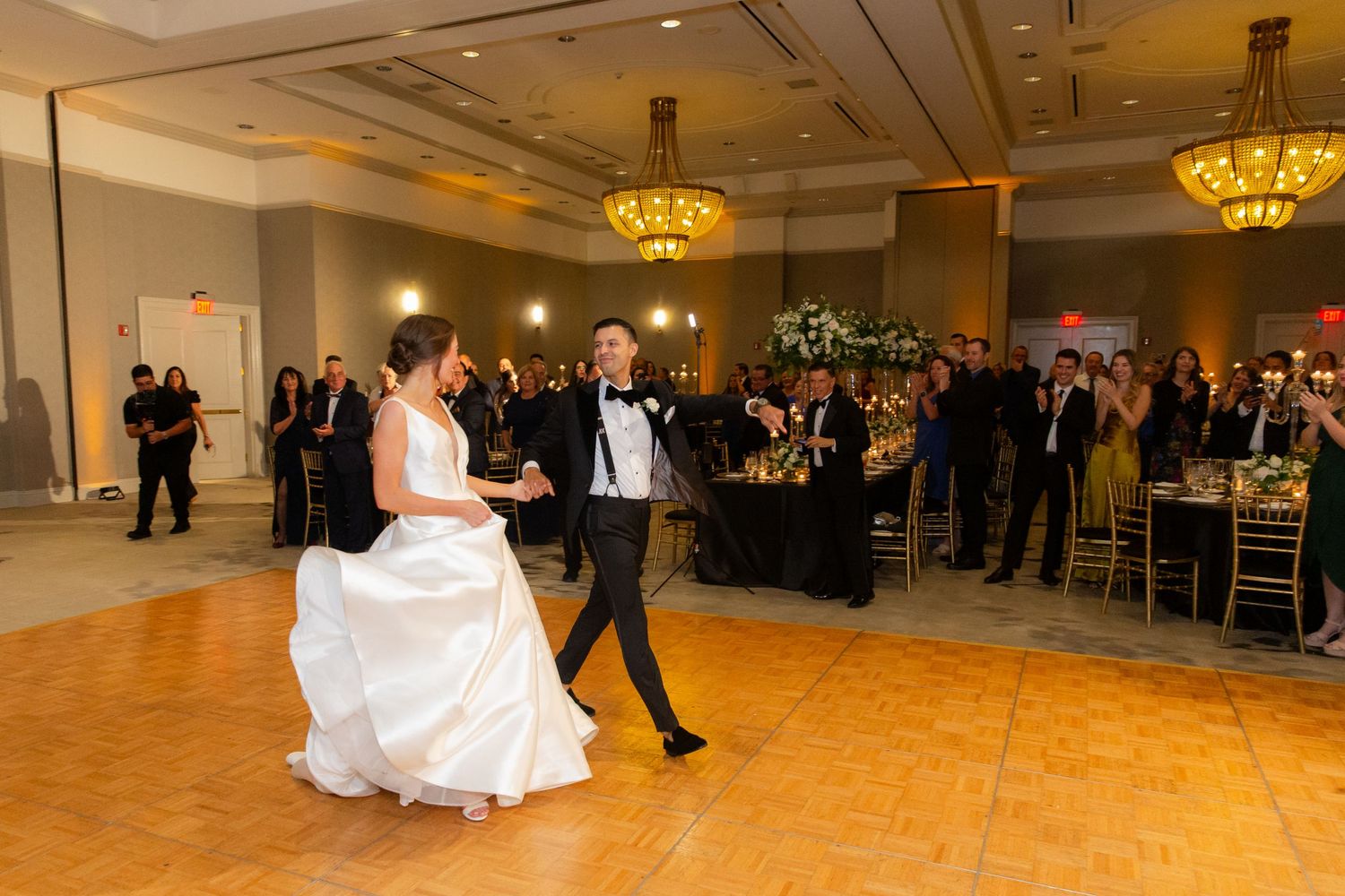 Large ballroom dance floor with guests celebrating at an elegant wedding reception.