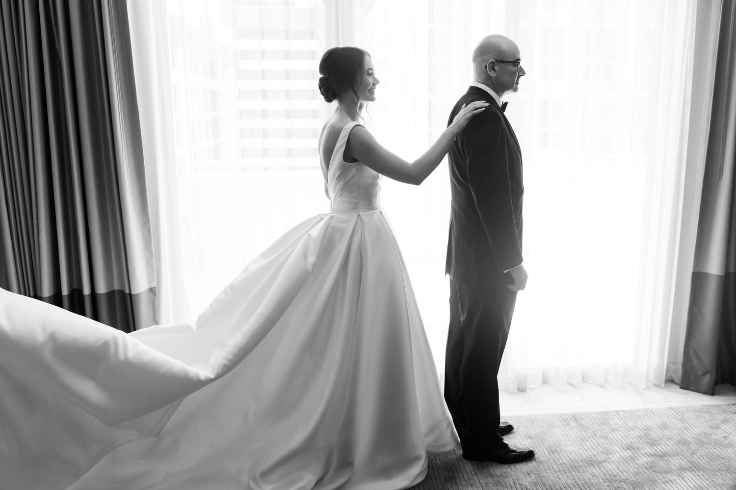 An elegant wedding dress flows gracefully in a bright, sunlit room.